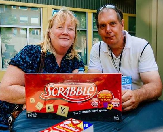 Photo of two lucky geocachers who won the Scrabble board game and Scrabble Dictionary at the 2014 Geocaching Block Party