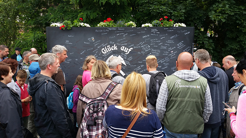 Geocachers gather around the logbook